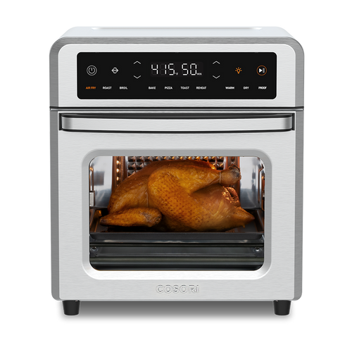Cosori 13-Quart Air Fryer Oven with a whole roasted chicken cooking inside. Stainless steel finish